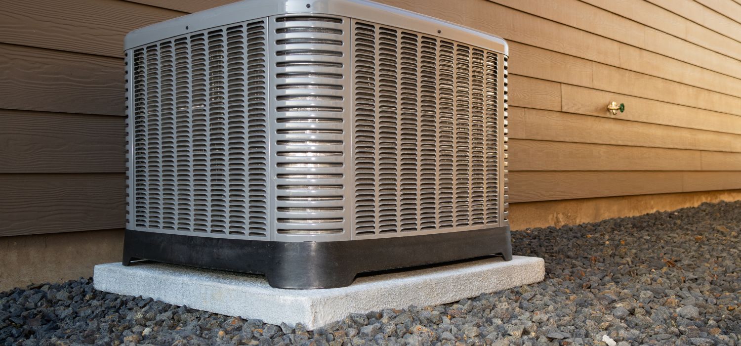 Outdoor energy-efficient HVAC condenser unit installed on a concrete pad beside a home.
