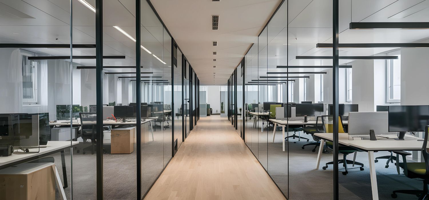 Modern office interior with glass partitions, workstations, and open corridors designed for a clean and organized commercial workspace.